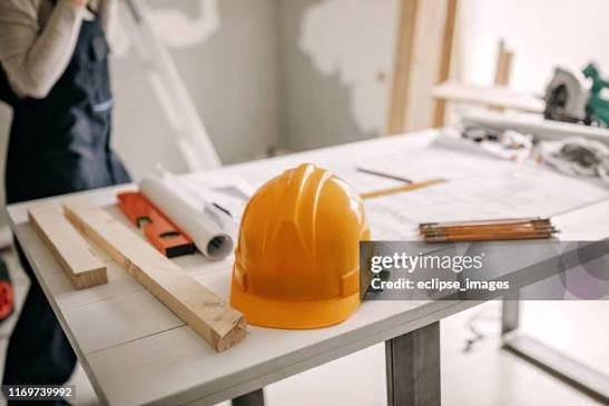 Casco de obra y planos sobre una mesa de trabajo